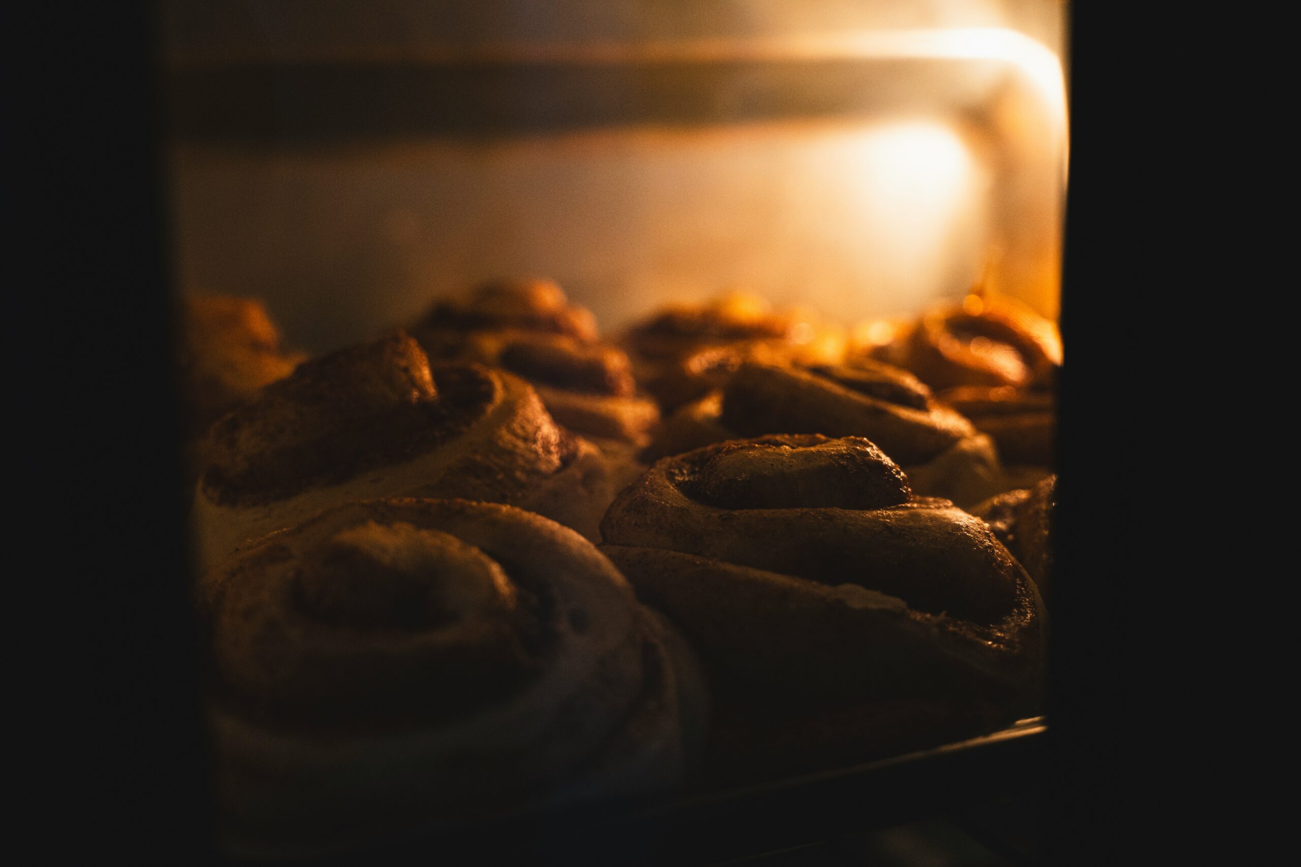 A close up of a bunch of doughnuts baking in an oven