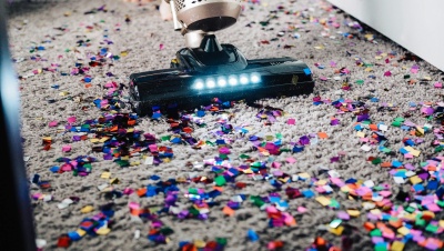 a person using a vacuum to clean a carpet